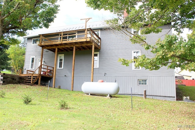 rear view of house with a wooden deck and a yard