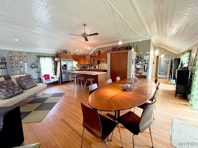 dining room with lofted ceiling, ornamental molding, ceiling fan, and light hardwood / wood-style flooring