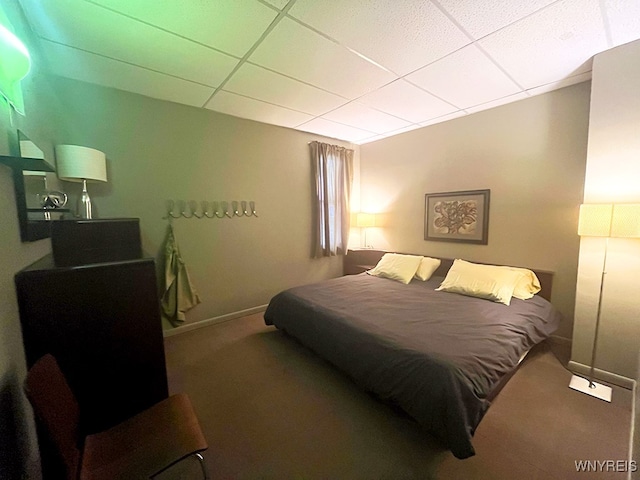 bedroom featuring a drop ceiling and carpet flooring