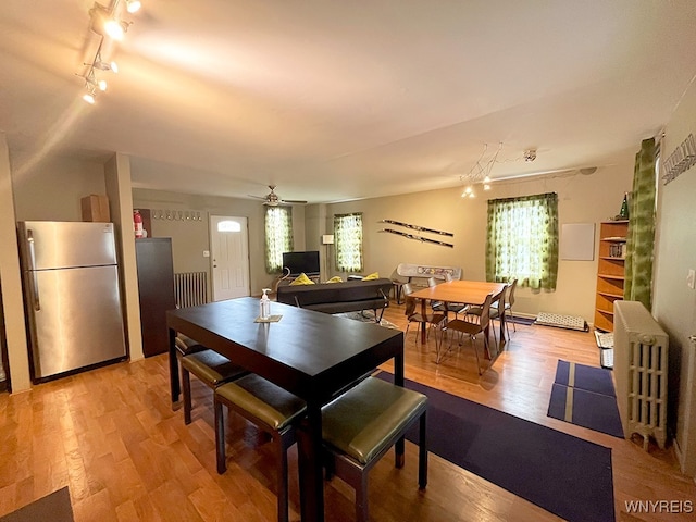 dining area featuring light wood-type flooring, ceiling fan, and plenty of natural light