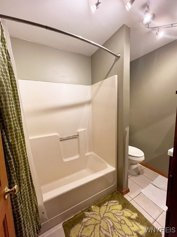 bathroom featuring shower / bath combo with shower curtain, tile patterned flooring, and toilet