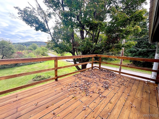 wooden terrace featuring a lawn