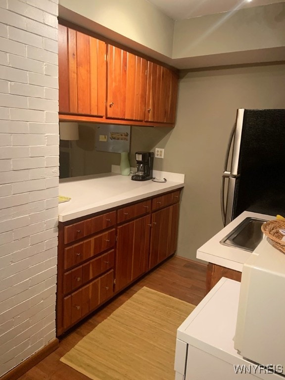 kitchen with refrigerator, hardwood / wood-style floors, and sink