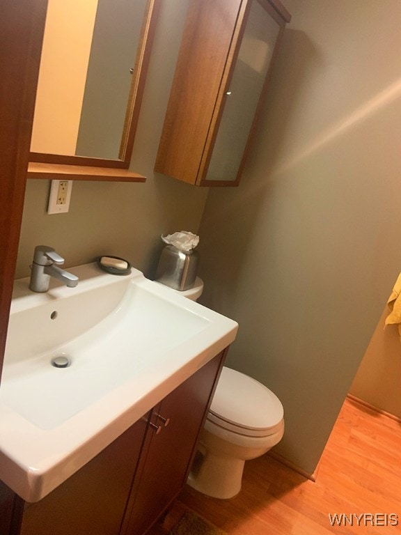 bathroom with wood-type flooring, vanity, and toilet