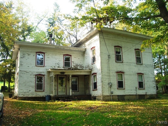 back of property featuring a lawn