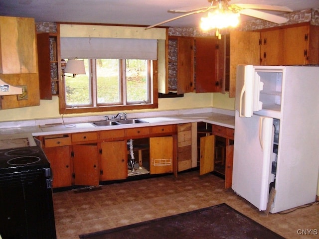 kitchen featuring white refrigerator, black electric range oven, ceiling fan, and sink