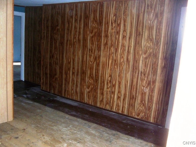 unfurnished room featuring wood walls