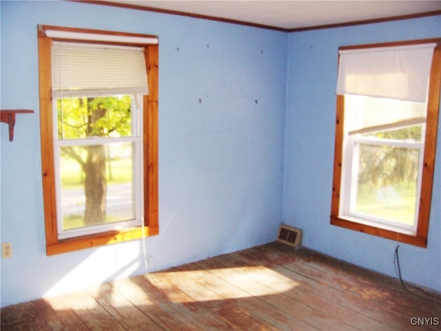 unfurnished room featuring light wood-type flooring and crown molding