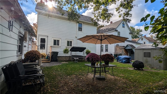 rear view of property featuring a lawn and a storage shed