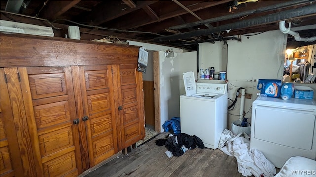 clothes washing area featuring hardwood / wood-style flooring and washing machine and dryer