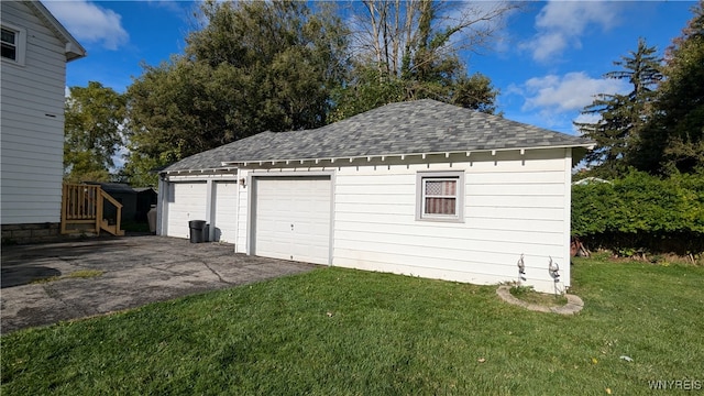 garage with a yard and wood walls