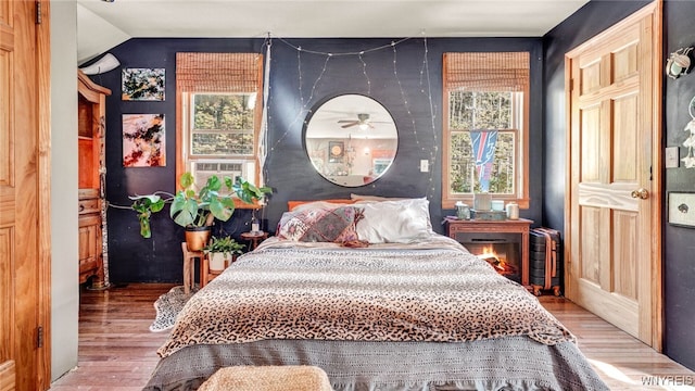 bedroom with wood-type flooring and vaulted ceiling