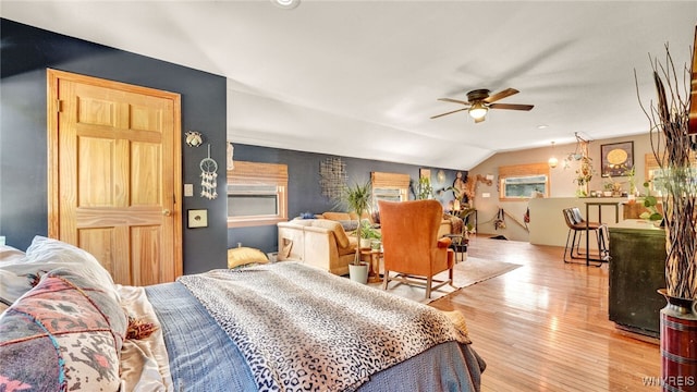 bedroom with ceiling fan, vaulted ceiling, multiple windows, and light hardwood / wood-style flooring