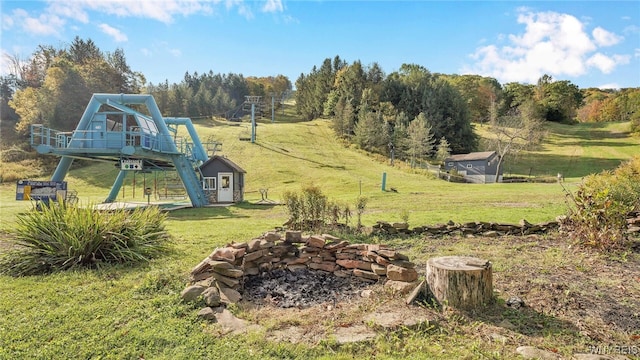 view of yard featuring a playground and an outdoor fire pit