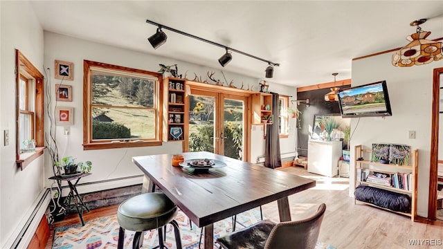 dining space with light hardwood / wood-style floors, french doors, rail lighting, and a baseboard radiator