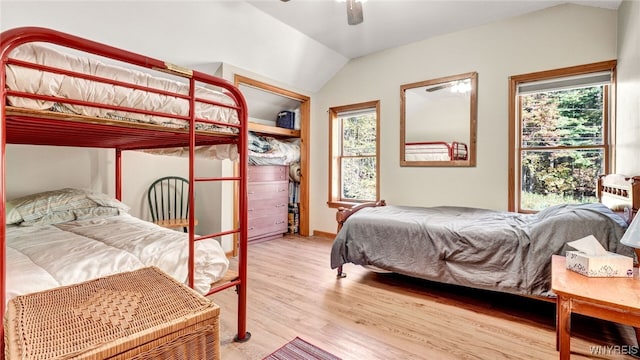 bedroom with ceiling fan, light wood-type flooring, and lofted ceiling