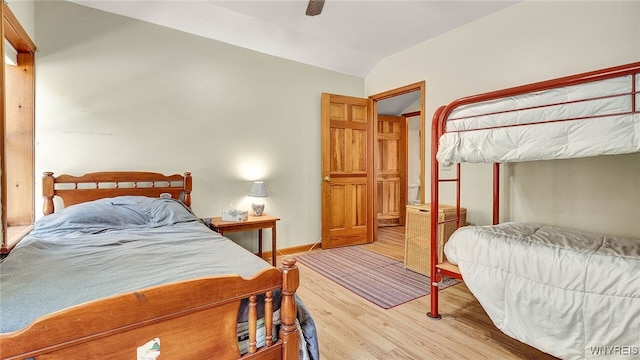 bedroom featuring ceiling fan, light wood-type flooring, and lofted ceiling