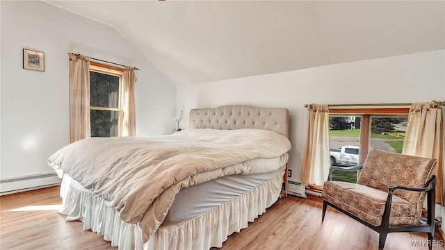 bedroom featuring baseboard heating, vaulted ceiling, and light wood-type flooring