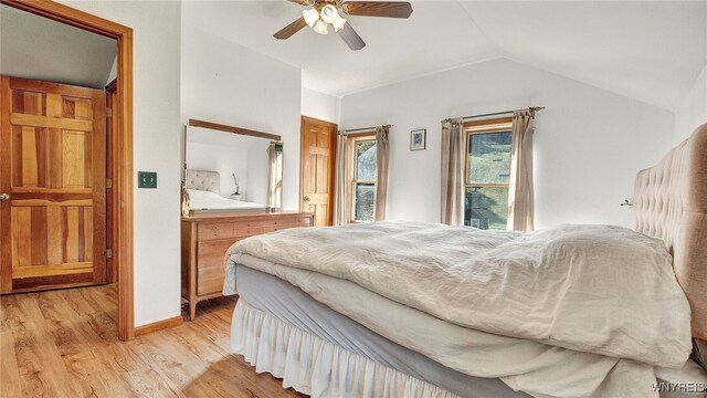 bedroom with ceiling fan, light hardwood / wood-style flooring, and lofted ceiling