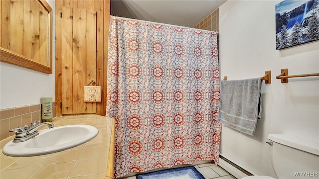 bathroom featuring tile patterned floors, toilet, sink, and a baseboard heating unit