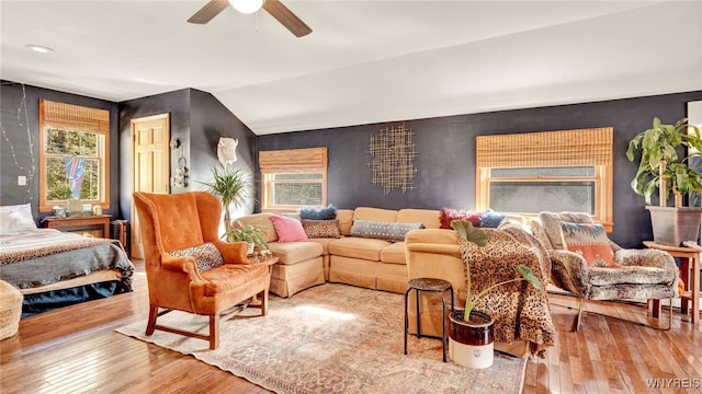 living room featuring ceiling fan, light wood-type flooring, and lofted ceiling