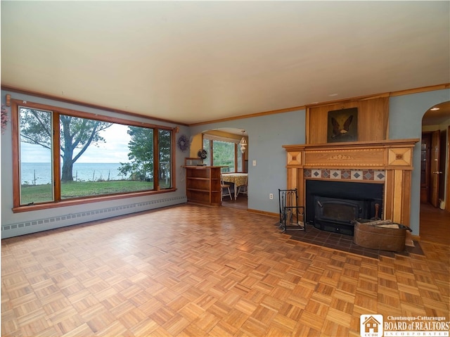 unfurnished living room featuring parquet floors, a water view, plenty of natural light, and a baseboard radiator