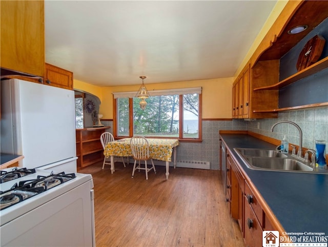 kitchen featuring pendant lighting, a baseboard heating unit, light wood-type flooring, sink, and white appliances