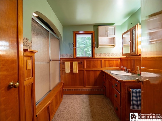 bathroom featuring wooden walls and vanity