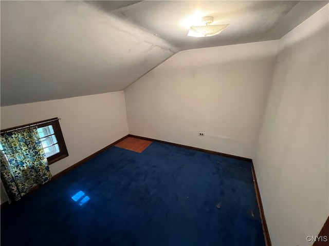 additional living space with vaulted ceiling and carpet