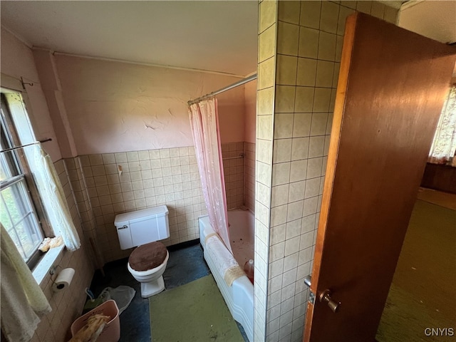 bathroom with shower / bath combo, tile walls, and toilet