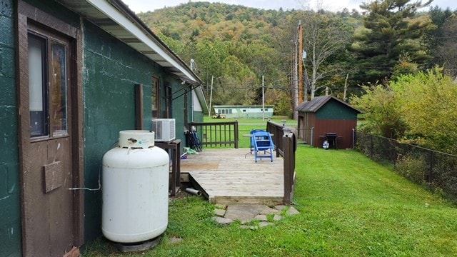 view of yard with a storage unit and a deck with mountain view