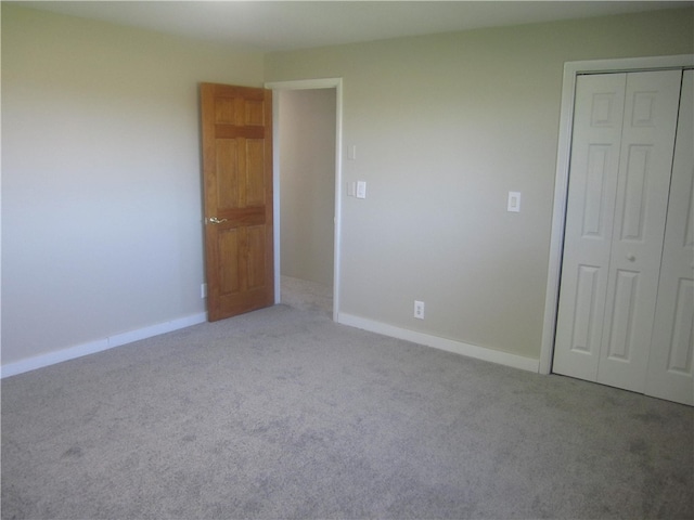 unfurnished bedroom with light carpet and a closet