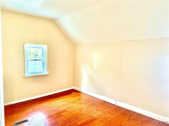 additional living space featuring lofted ceiling and hardwood / wood-style floors