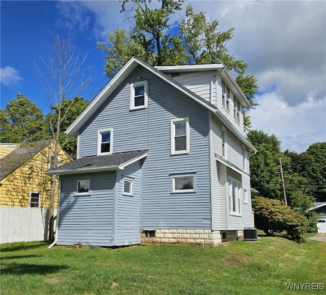 rear view of property with a yard and central air condition unit