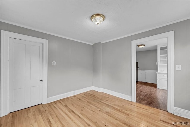 empty room featuring hardwood / wood-style flooring and ornamental molding