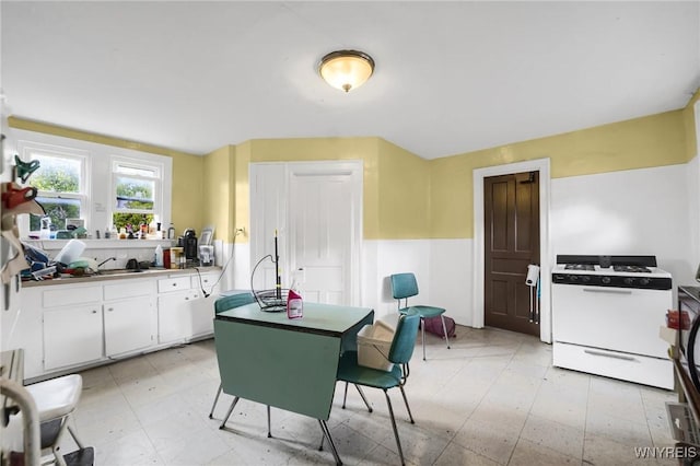 kitchen featuring white cabinetry and white gas range oven