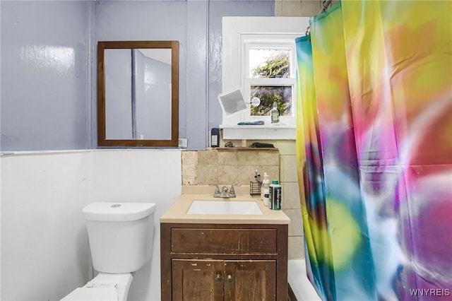 full bathroom featuring vanity, toilet, decorative backsplash, and shower / tub combo with curtain