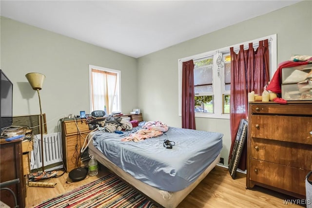 bedroom with light wood-type flooring and radiator