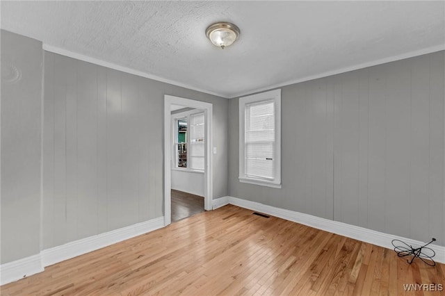 unfurnished room with hardwood / wood-style flooring and crown molding