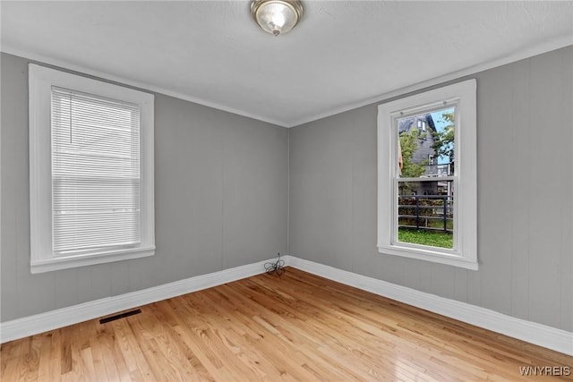 spare room with hardwood / wood-style flooring and a healthy amount of sunlight