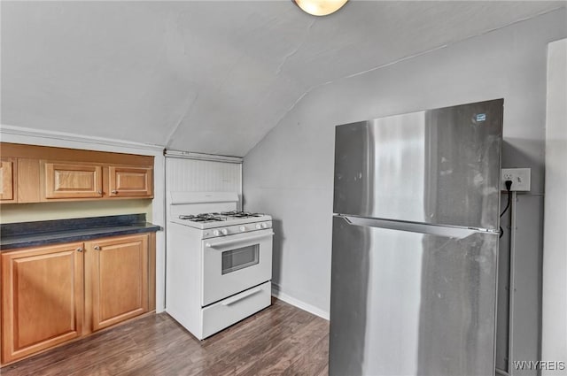 kitchen with white gas range oven, stainless steel refrigerator, dark hardwood / wood-style floors, and lofted ceiling