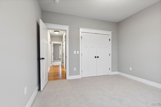 unfurnished bedroom with light carpet and a closet