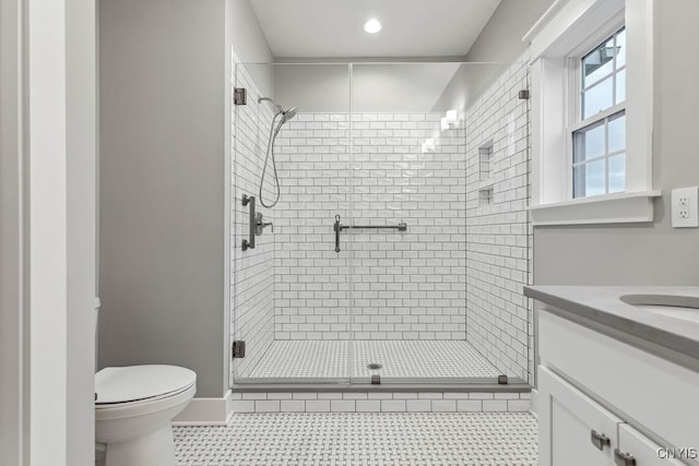 bathroom with walk in shower, vanity, toilet, and tile patterned floors