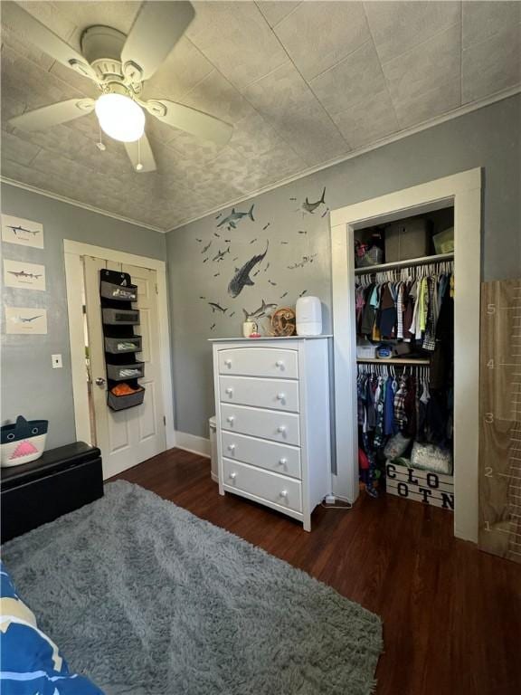 bedroom with dark hardwood / wood-style flooring, ornamental molding, a closet, and ceiling fan