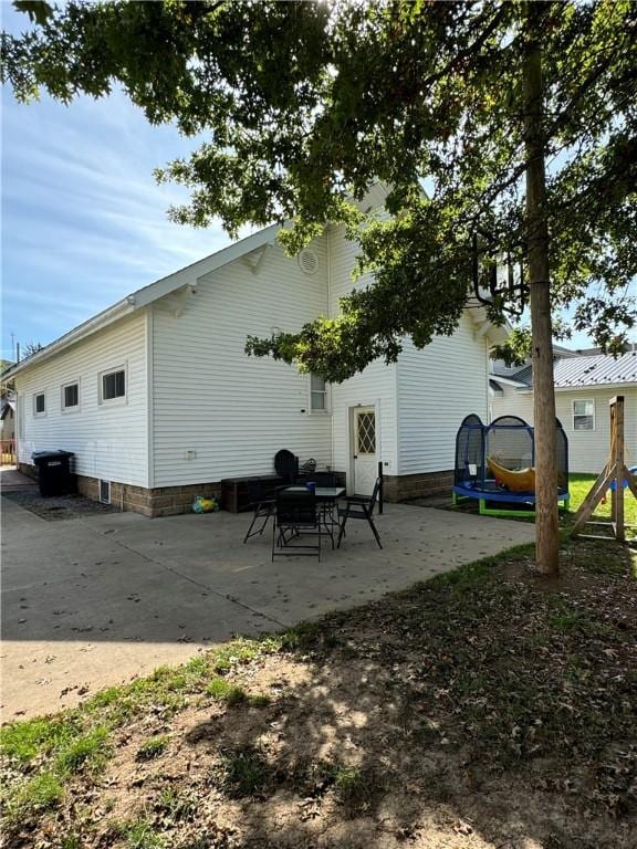 back of house featuring a trampoline and a patio area