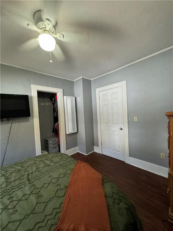 bedroom featuring dark wood-type flooring, ornamental molding, and ceiling fan