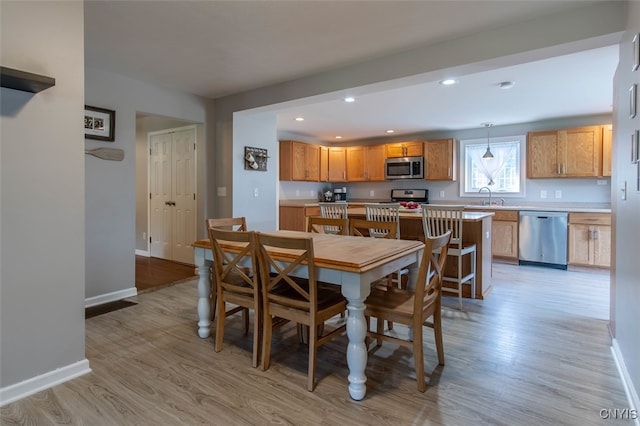 dining space featuring light hardwood / wood-style floors and sink