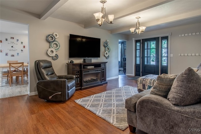 living room featuring beam ceiling, hardwood / wood-style flooring, and a notable chandelier