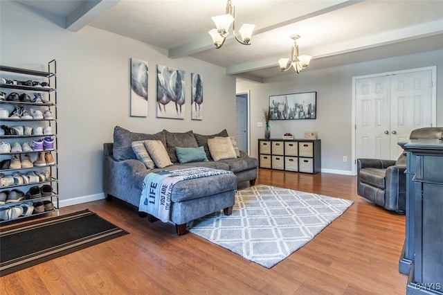 living room with beam ceiling, an inviting chandelier, and hardwood / wood-style floors