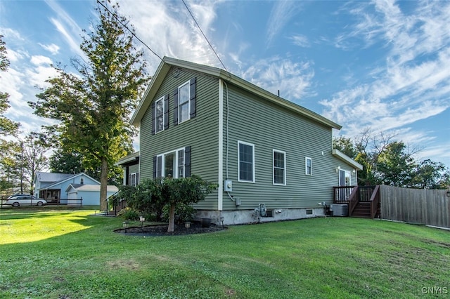 back of house featuring a lawn and central air condition unit